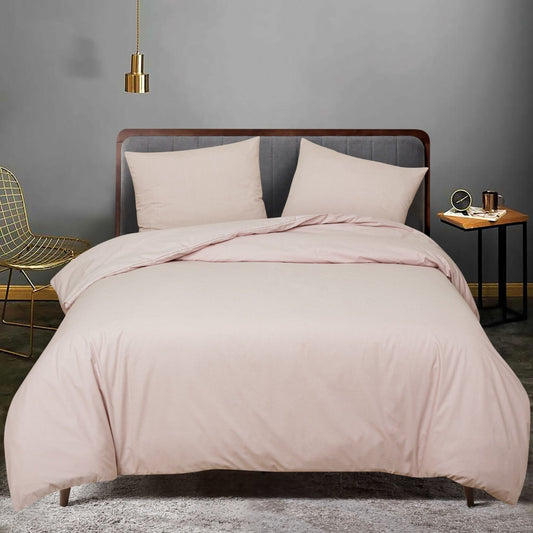 Pink bedding set on a bed in a room with a gray wall and gold chair, featuring ZM Textiles Belgium dyed duvet cover set.