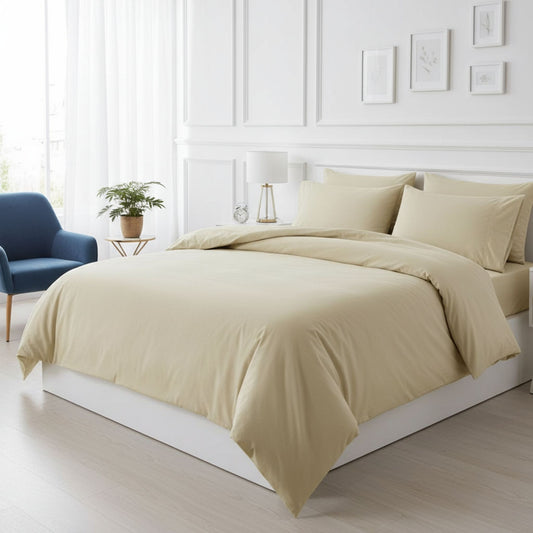 Beige bedding set on a bed in a bright bedroom with a blue chair and plant, featuring ZM Textiles Belgium dyed duvet cover set.