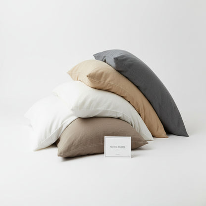 Stack of neutral-colored pillows on a white background, featuring ZM Textiles Belgium dyed pillowcase set.