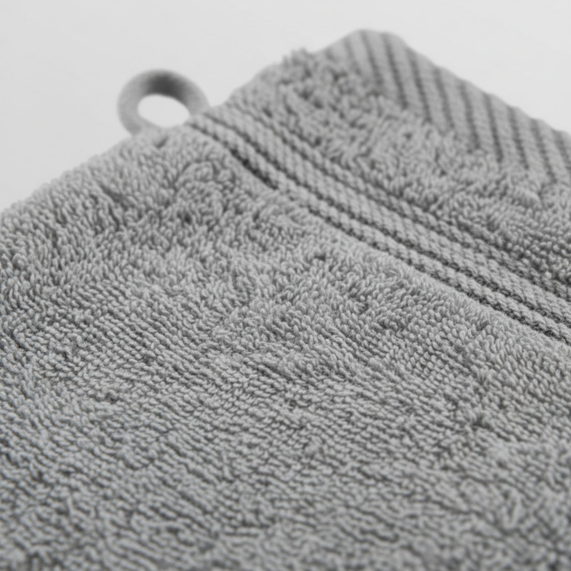Gray textured wash glove with a circular hole, likely for hanging, featuring ZM Textiles Belgium wash gloves.