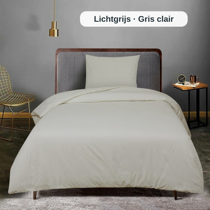 Ordentlich gemachtes Bett mit weißer Bettwäsche in einem modernen Schlafzimmer, mit dem uni Bettbezug-Set von ZM Textiles Belgium.