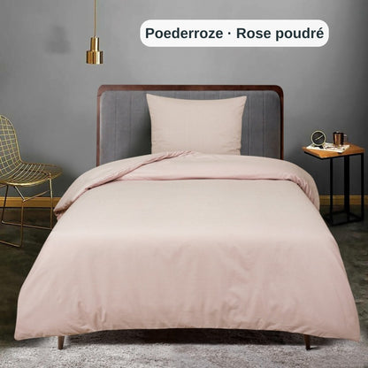 Bett mit rosa Bettwäsche und grauen Wänden in einem modernen Schlafzimmer, mit dem uni Bettbezug-Set von ZM Textiles Belgium.