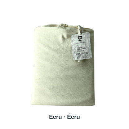 Bett mit Matratzenbezug und Nahaufnahme der Verpackung in einem Schlafzimmer, mit den Flanell-Spannbettlaken von ZM Textiles Belgium.