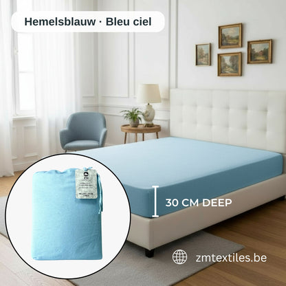 Blauer Matratzenbezug auf einem Bett mit Nahaufnahme des Produkts und Markenlogos, mit den Flanell-Spannbettlaken von ZM Textiles Belgium.