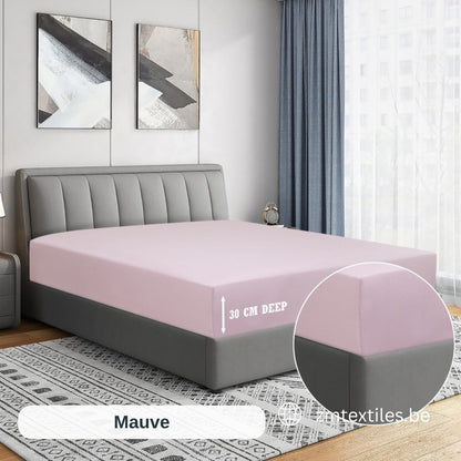 Lila Matratzenbezug auf einem Bett in einem Schlafzimmer mit dem Schriftzug „intextiles.be“, mit den T144 Baumwoll-Spannbettlaken von ZM Textiles Belgium.